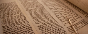 Parchemin de la Torah ouvert avec un pointeur (yad) indiquant les commandements de Dieu.